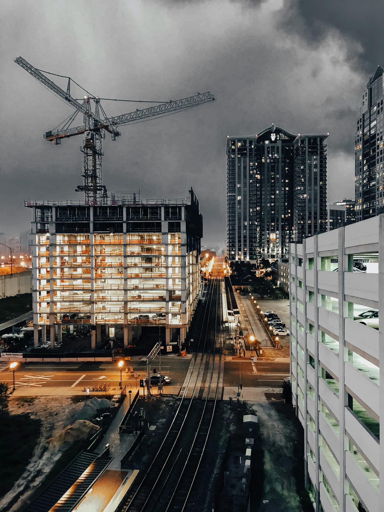 Multi-storey building under construction at dusk with a tower crane